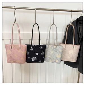 Quatre sacs cabas à fleurs en rose, noir, bleu et beige suspendus en une rangée