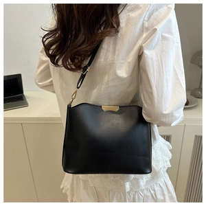 Vue arrière d'un mannequin portant un sac bandoulière noir avec des détails dorés chic