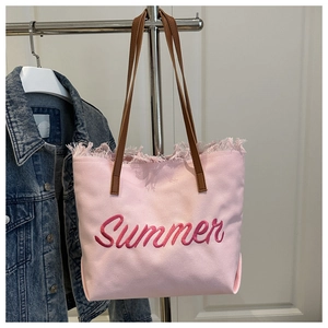 Détail du sac cabas en toile rose avec broderie Summer et bordures à franges