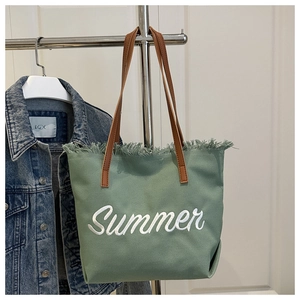 Détail du cabas en toile verte avec broderie Summer blanche et bords effilochés