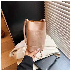Detail of light pink lychee texture leather mini bucket bag with slim shoulder strap