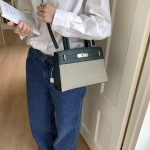 Chic green and beige panelled handbag with gold twist lock and adjustable strap
