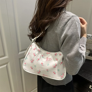 Retro underarm bag with pink rose and bow floral pattern worn on the shoulder
