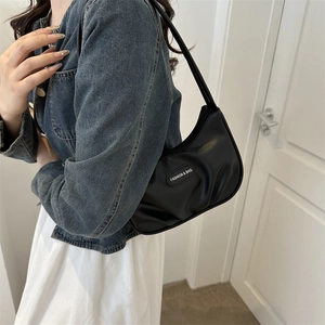 Schwarze minimalistische Hobo-Achseltasche mit Faltendesign und FASHION & BAG Schriftzug am Model