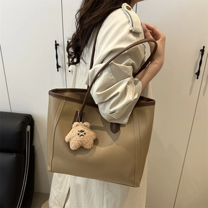 Minimalist earth-tone tote bag with plush star charm shown on model shoulder