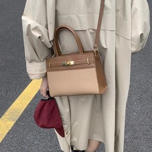 Retro canvas and brown leather crossbody bag with gold buckle on a stylish model