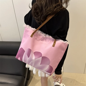 Pink canvas beach tote bag with fringe edge and gradient pattern on a model