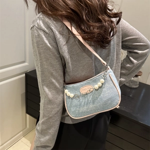 Chic blue denim underarm bag with pink trim, pearl chain and fashion label detail