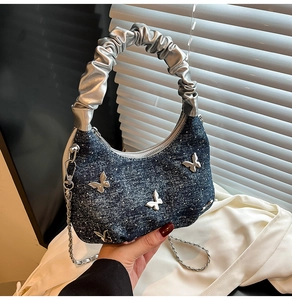 Détail du sac croissant en jean bleu avec paillettes brillantes et papillons argentés