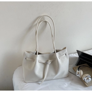 Vue détaillée du sac cabas blanc crème avec texture tressée et boucles métalliques