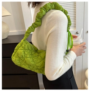 Detail der grünen Stepptasche mit gerafftem Griff und Puffer-Design am Modell