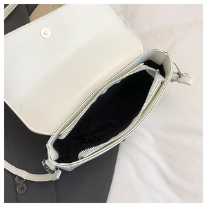 Top view of white saddle bag interior with silver magnetic buckle and zipper pocket