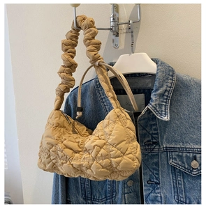 Nahaufnahme der khakifarbenen Stepptasche mit plissiertem Trageriemen und Tunnelzug-Detail