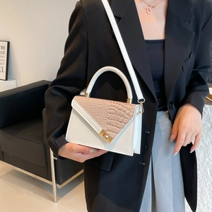 Modern white and brown stone pattern crossbody bag with golden clasp shown on a model