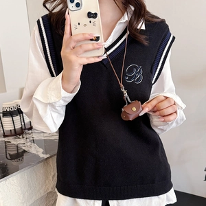 Mini pendentif portefeuille en cuir sur un gilet en maille à col en V de style collège
