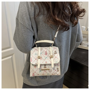 Detailed side view of beige cartoon crossbody bag featuring cute rabbit and bear prints