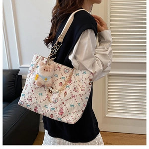 Close-up of cute cartoon tote bag featuring plush bunny charm and pearl chain details