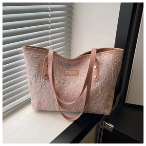 Dettaglio borsa shopper rosa con ricami a onde colorate e motivo geometrico a rombi