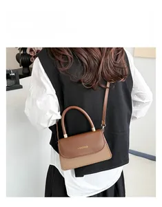 Close-up of brown patchwork bag featuring suede texture and FASHION & BAGS lettering
