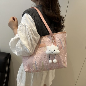 Borsa tote rosa trapuntata con ricamo e ciondolo a nuvola indossata da una modella