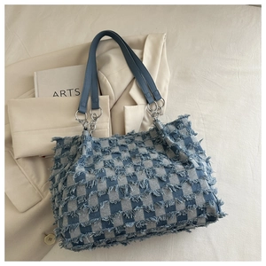 Detail der blauen Denim-Tote-Bag mit Schachbrettmuster, Fransen und silberner Kette