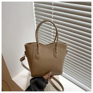 Macro detail of khaki leather bucket bag with FASHION logo and adjustable strap