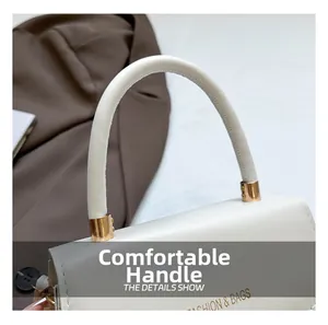Detail view of the elegant curved handle and gold logo on the beige leather handbag