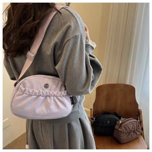 Detail of light purple pleated crossbody bag with FANTISSA label and adjustable strap