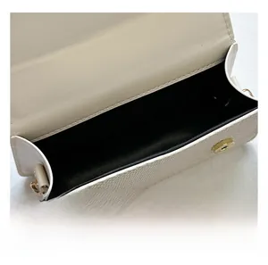 Detail showing internal compartment of cream faux leather shoulder bag with magnetic closures