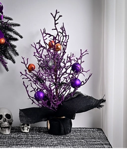 Detail of purple Halloween glitter tree with spooky spider ornaments and burlapped base