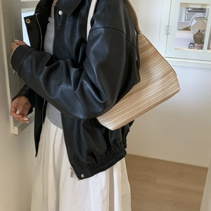 Handcrafted minimalist ice silk knit shoulder bag for women styled with a black faux leather jacket