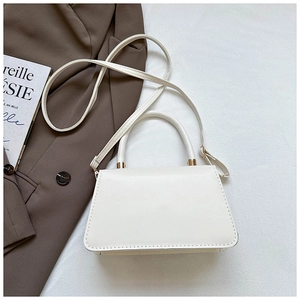 Detailed top view of a white structured handbag with golden metal hardware and strap