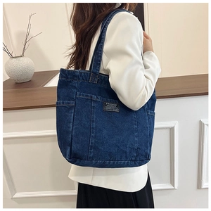 Detail view of large denim tote bag with Fashion Instinct label and side pocket