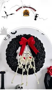 Gothic Halloween wreath detail with black roses, red bow, and twin skeleton ornaments