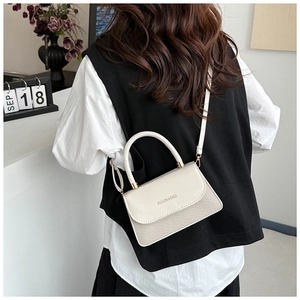 Chic cream-colored crossbody bag featuring woven texture and fashion slogan in a lifestyle setting