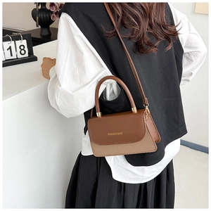 Close-up of elegant small square bag featuring brown leather and woven texture patchwork