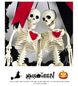 Detail of gothic Halloween wreath featuring twin skeletons with red hearts and black roses