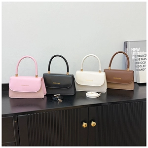 Detailed view of structured lady bags in pink, black, white, and brown with woven textures