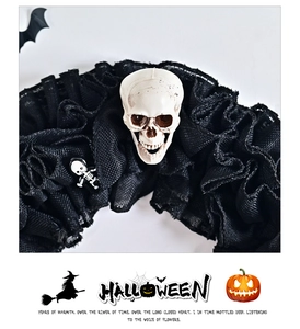 Close-up of Halloween wreath featuring gothic black mesh and detailed white skulls