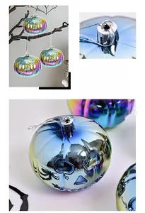 Detail of 8cm iridescent pumpkin ornaments with electroplated finish on black branches