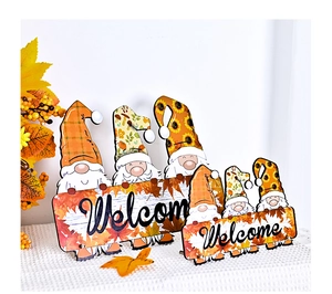 Detail of wooden Thanksgiving gnomes with Welcome sign and autumn leaf patterns