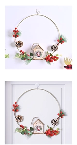 Detailed Christmas wreath featuring pine cones, red berries, and a miniature wooden cabin
