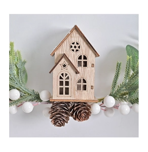 Detail of wooden Christmas house ornament with pine cones and winter berries decor