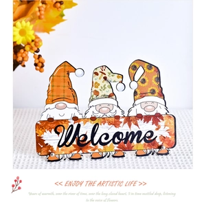 Close-up of three autumn gnomes holding a Welcome sign with maple leaf and floral accents