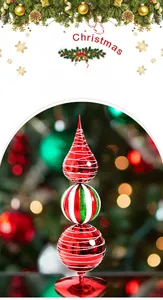 Close-up of a three-tier hand-painted metal Christmas tower ornament with red and green stripes