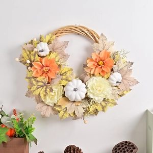 Autumn wreath with pumpkins and fall leaves on rustic woven base for harvest decor