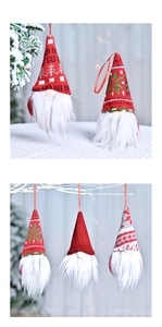 Close-up of knitted Christmas gnome ornaments with red and grey hats on a festive tree