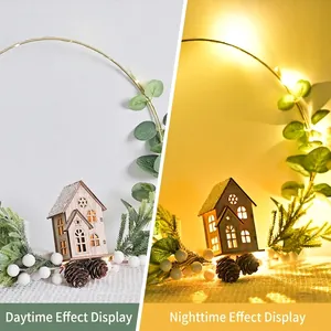 Christmas wreath with LED wooden house and pine cones showing day and night lighting effects