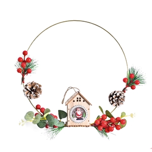 Christmas wreath with metal ring, pine cones, red berries and a small wooden house