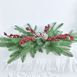 Christmas wreath with artificial pine needles, red berries, and snow-tipped pine cones